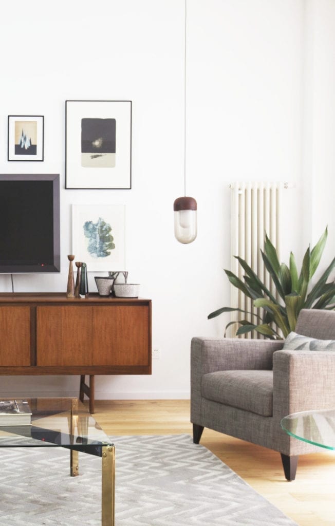 salon klimatyczne wnętrza białe ściany krzesło kanapa dywan stoliczki telewizor lampa komoda prl vintage