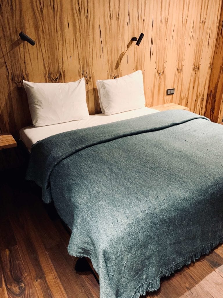 sypialnie-hotel-warszawa-drewniane-wezgłowie-poduszki-do-spania-punktowe-kinkiety-do-czytania-koc