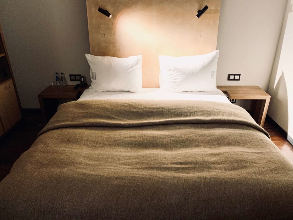 sypialnie-hotel-warszawa-drewniane-wezgłowie-poduszki-do-spania-punktowe-kinkiety-do-czytania-koc-lniany