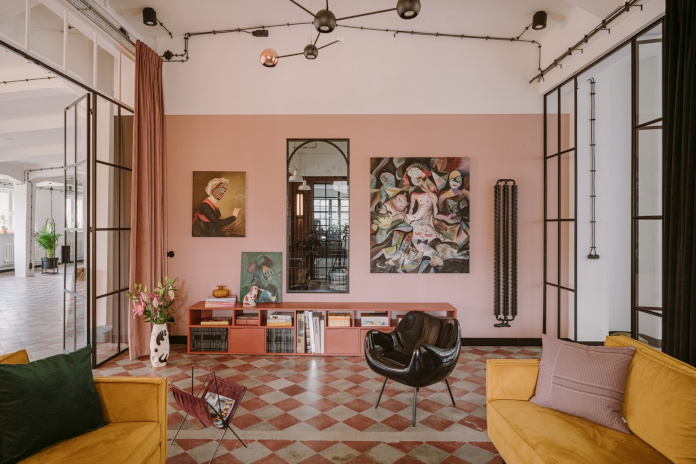 clay.warsaw w warszawie z różowymi ścianami w stylu vintage żółte sofy różowe pufy czarne krzesła podłoga w ktatkę
