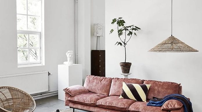 Jak dekorować wnętrza w 2020 roku? piękne-wnętrze-różowa-kanapa-welurowa-drewnainy-parkiet